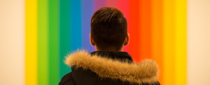 rainbow background with young person in foreground