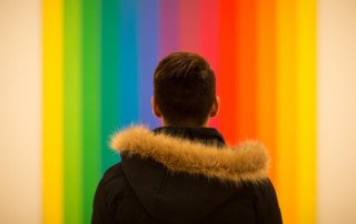 rainbow background with young person in foreground